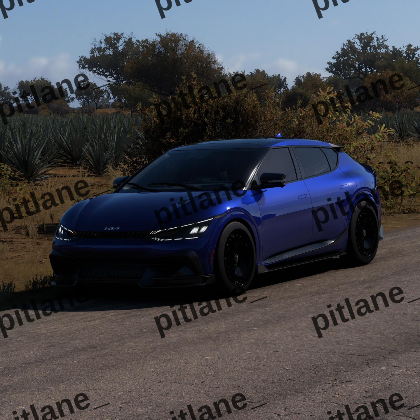 A blue compact SUV parked outdoors on a paved road with trees and shrubs in the background under a clear blue sky. The image has repeated 'pitlane_' watermarks and a 'Forz Motorsport' logo in the top right.