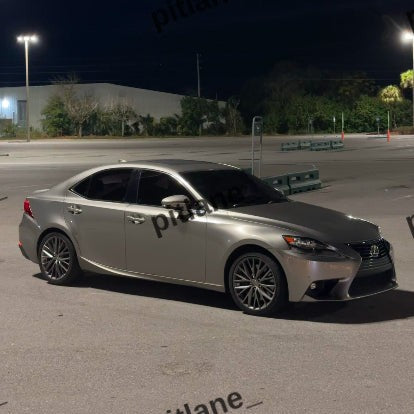 A silver Lexus sedan parked in an outdoor lot at night under streetlights.
